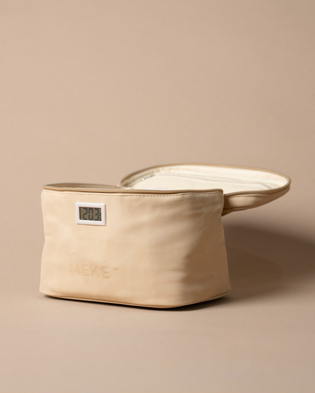 A cream coloured canvas milk pouch with a small digital temperature indicator window and embossed brand name, shown next to its matching lid on a solid beige background.