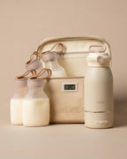 A beige MEEKI baby feeding and storage set on a warm beige background, including four milk pouches, a coller bag, a cream-colored milk warmer
